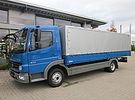 Ein blauer LKW mit Plane
