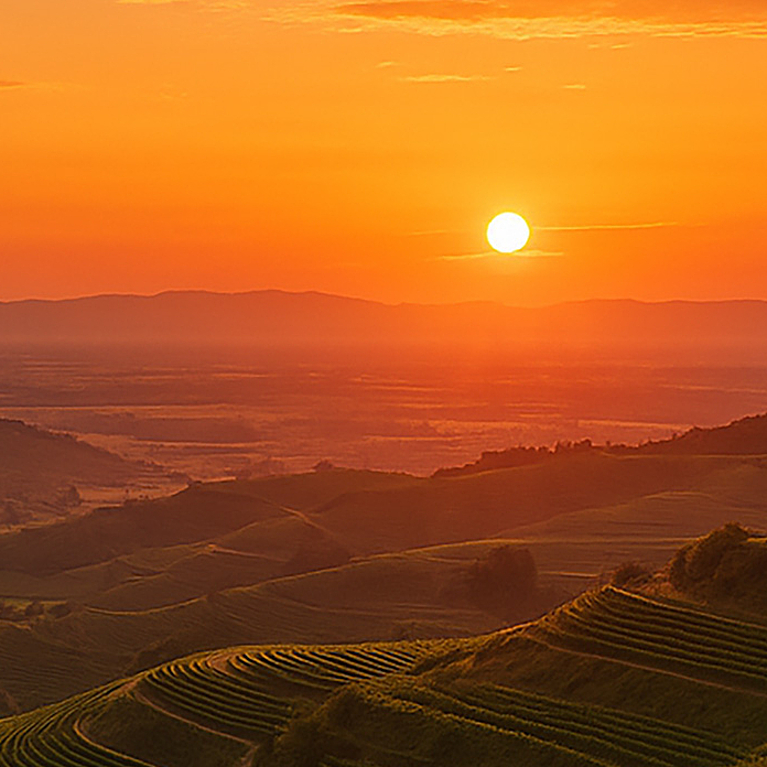 Ein orangener Sonnenuntergang über dem Panorama des Kaiserstuhls